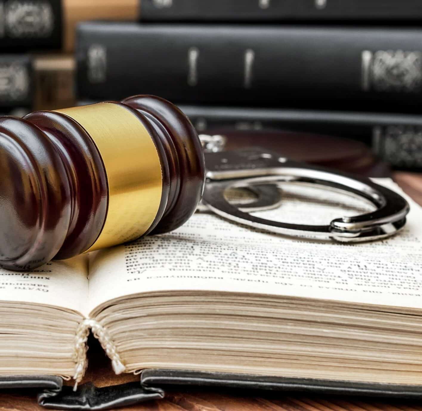 Gavel with handcuffs on opened book. Close up. Justice concept.