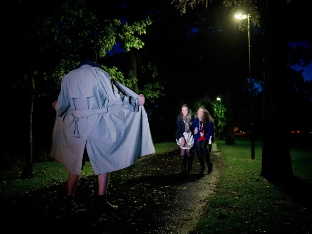 A man walking down a path with a man in a trench coat.