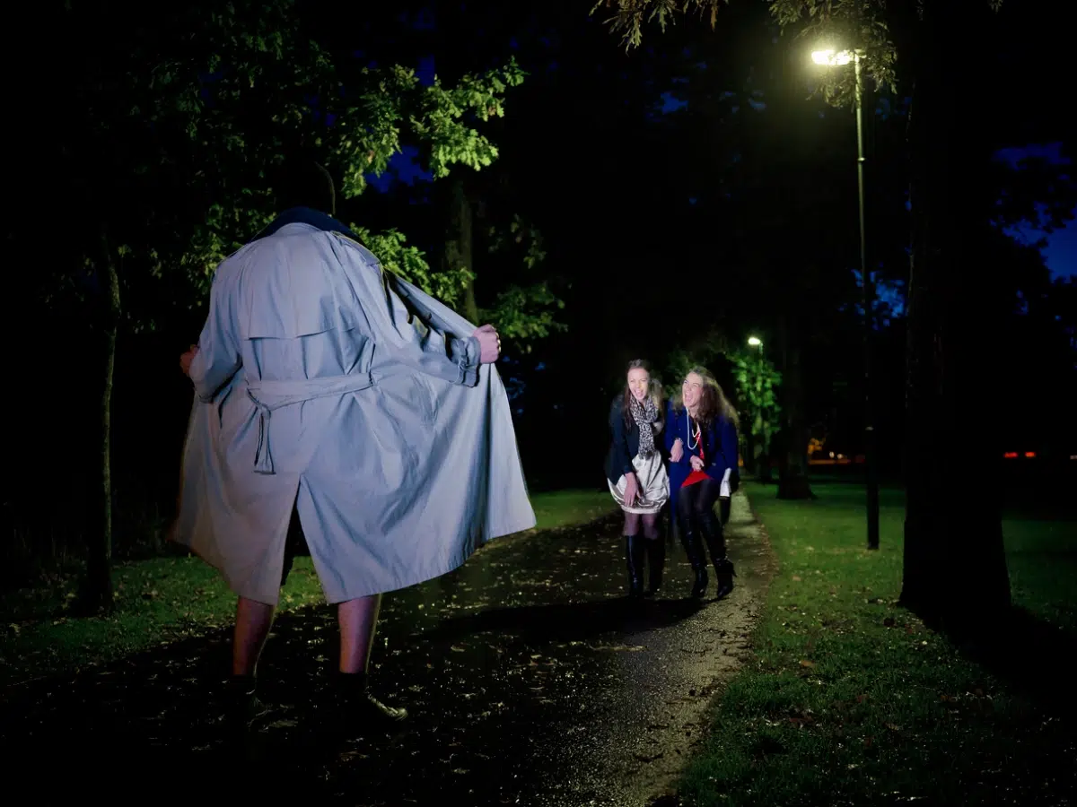 A man walking down a path with a man in a trench coat.
